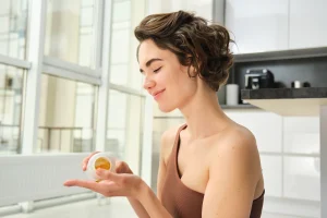 Mujer tomando suplemento vitamínico para fortalecer el sistema inmune en casa