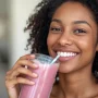 Mujer tomando batido de proteína vegana saludable en casa