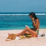 Mujer aplicando protector solar durante unas vacaciones en la playa