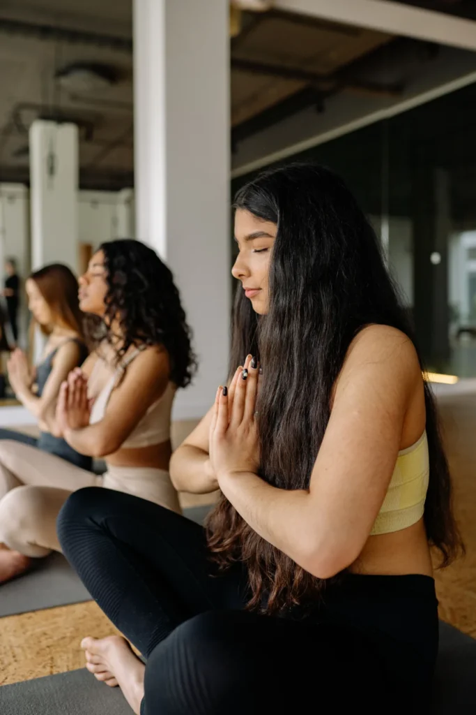 Personas practicando meditación y respiración consciente como parte de hábitos saludables para reducir el estrés y promover el bienestar emocional.
