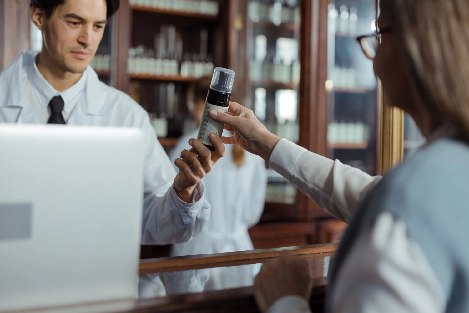 Farmacéutico entregando medicamentos homeopáticos en una farmacia especializada de Bogotá.