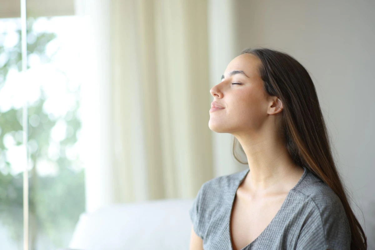 Mujer respirando con calma para recuperar el bienestar después de una situación de estrés